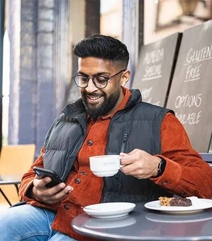 Man sat outside restaurant looking at phone 